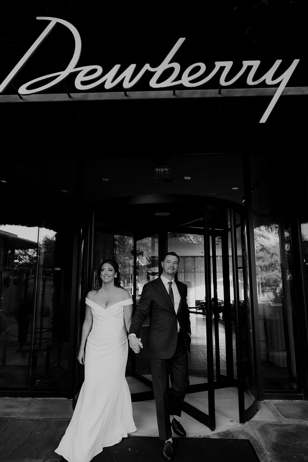 Couple walking out of revolving door at the dewberry