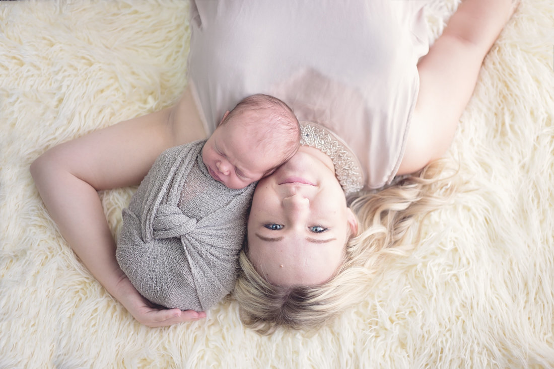 Photograph of mother holding her newborn  by Plume Designs & Photography, Scottsdale Arizona Newborn Photographer