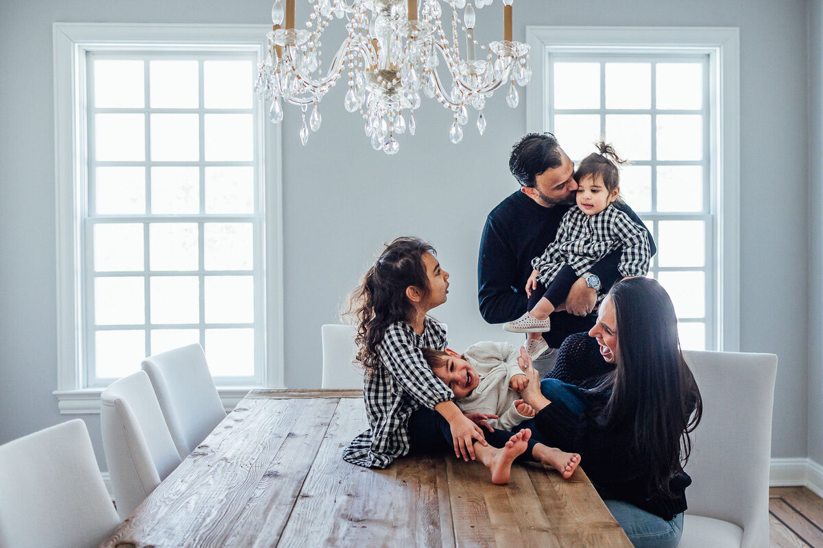 family laughing sitting at dining room table long island photography