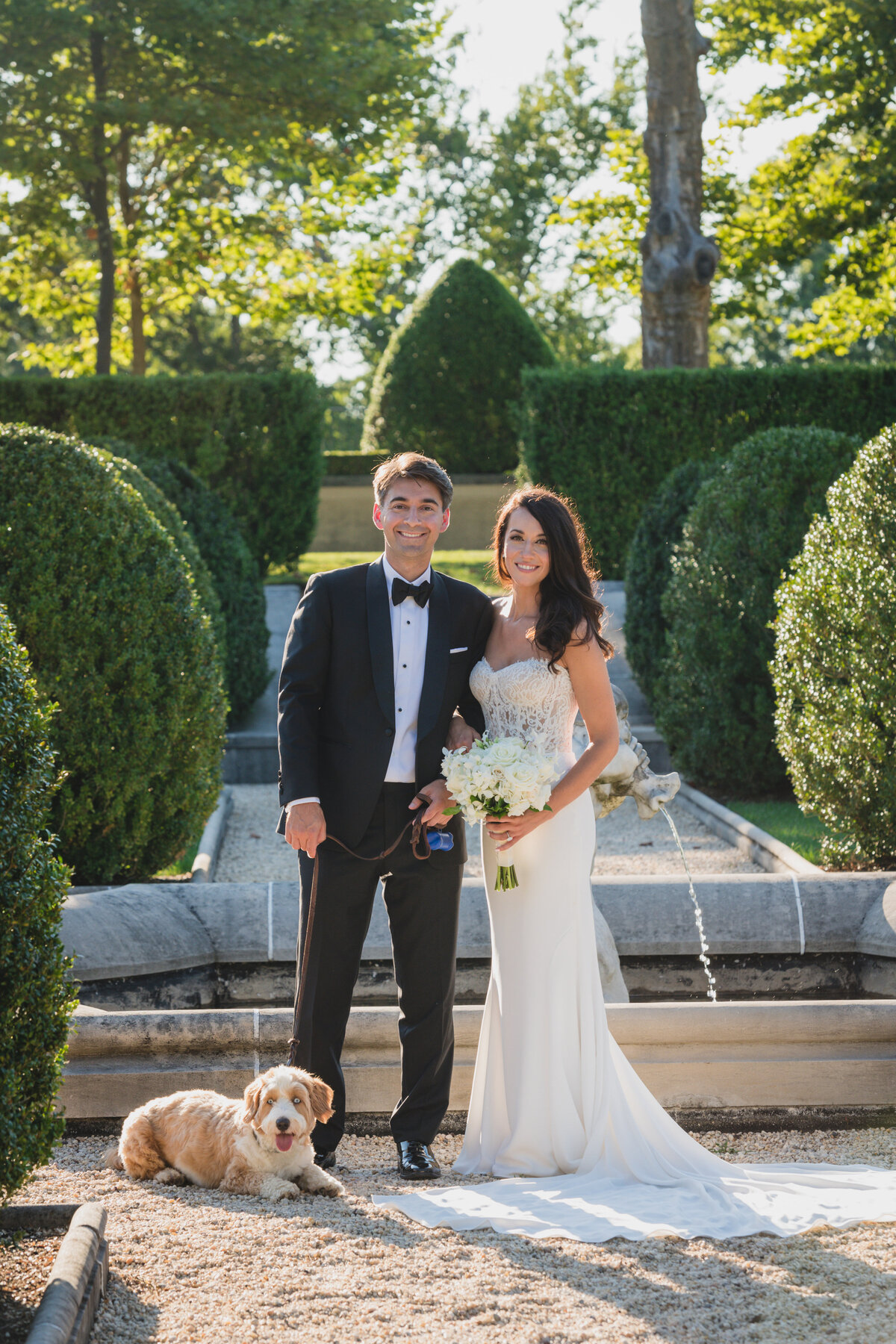 bride and groom outside Oheka Castle with their dog