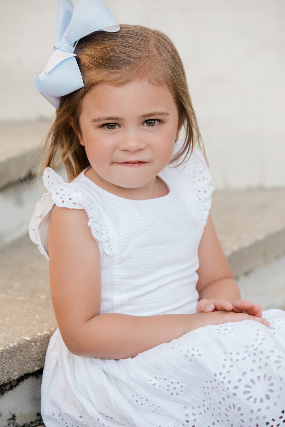 A small child sitting on a staircase smiling