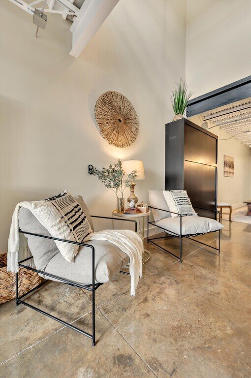 Comfortable seating area and Murphy bed in the living room of this 2 bedroom, 2.5 bathroom luxury vacation rental loft condo for 8 guests with incredible downtown views, free parking, free wifi and professional decor in downtown Waco, TX.