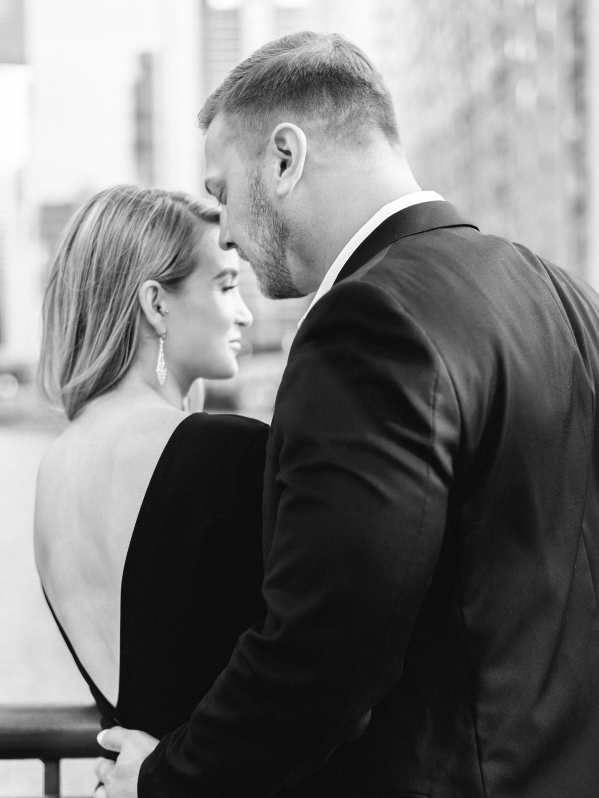 engaged couple wearing elegant suit and backless black dress