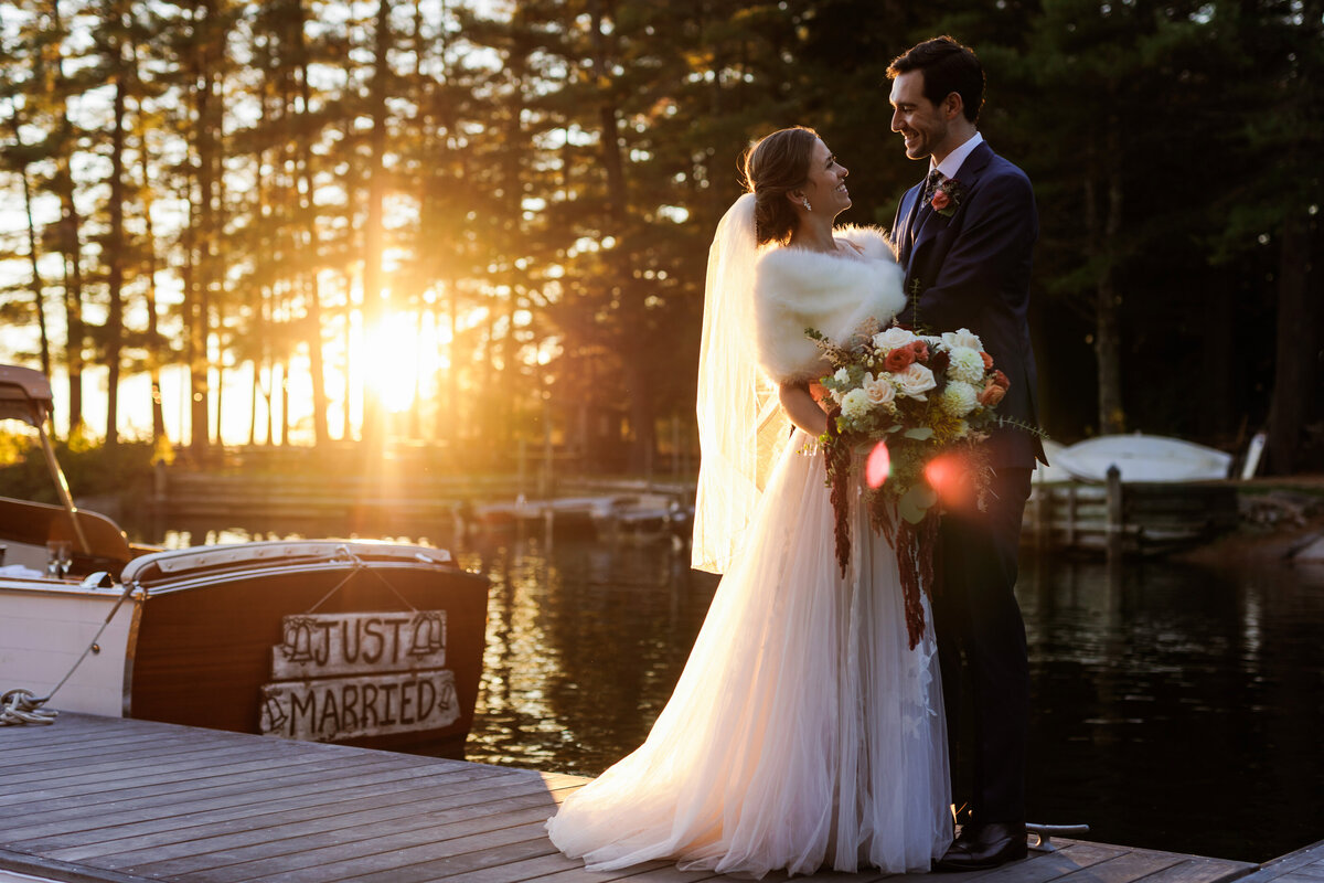 Sun sets behind the couple and the boat at Migis Lodge Resort