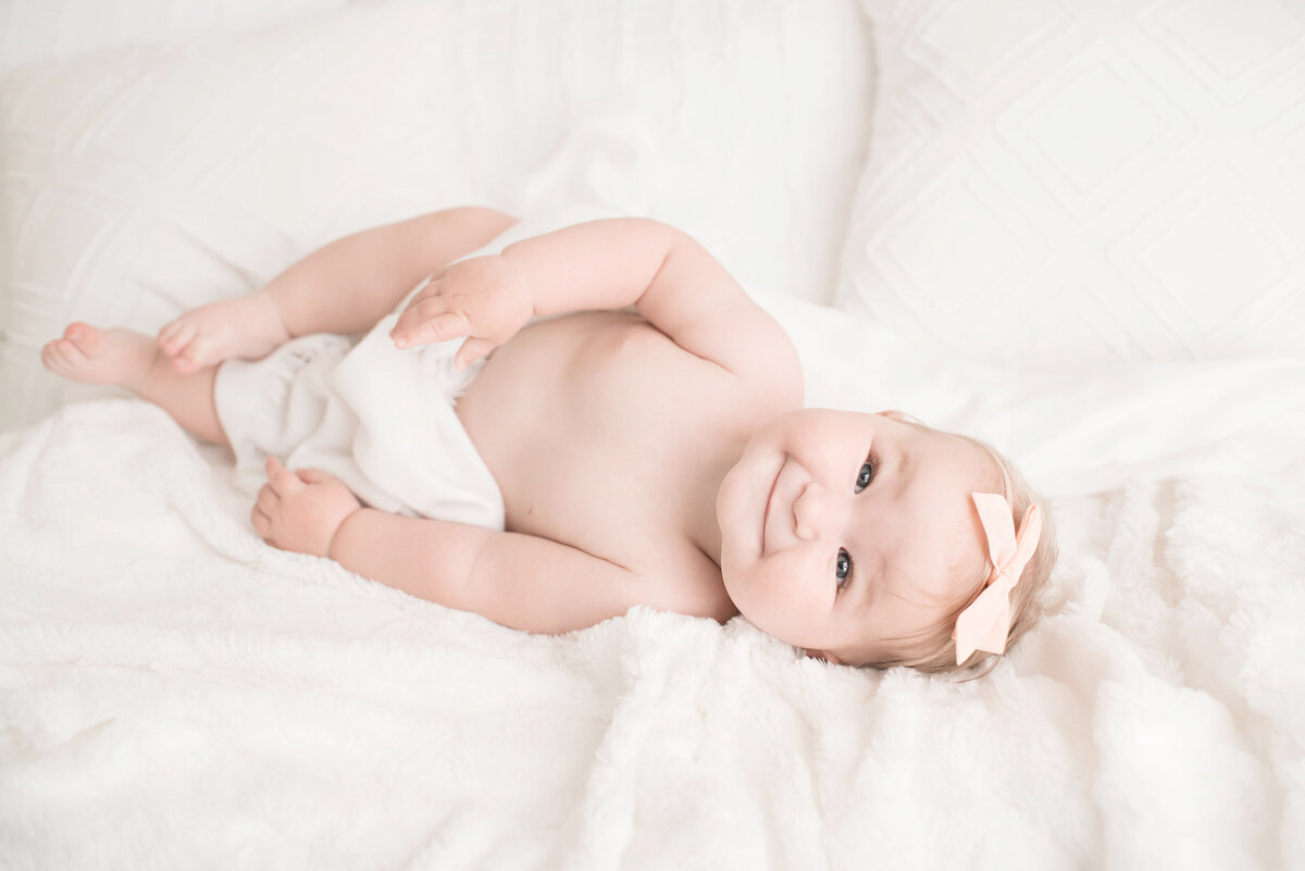 6 month baby smiling on bed