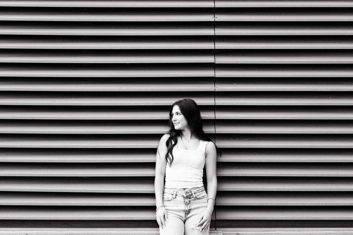 girl with dark hair in front of metal garage