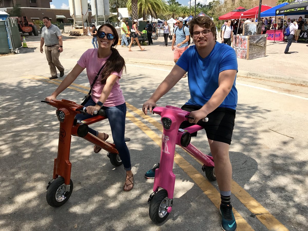 College couple sitting on Pink & Bronze Go-Bike M1
