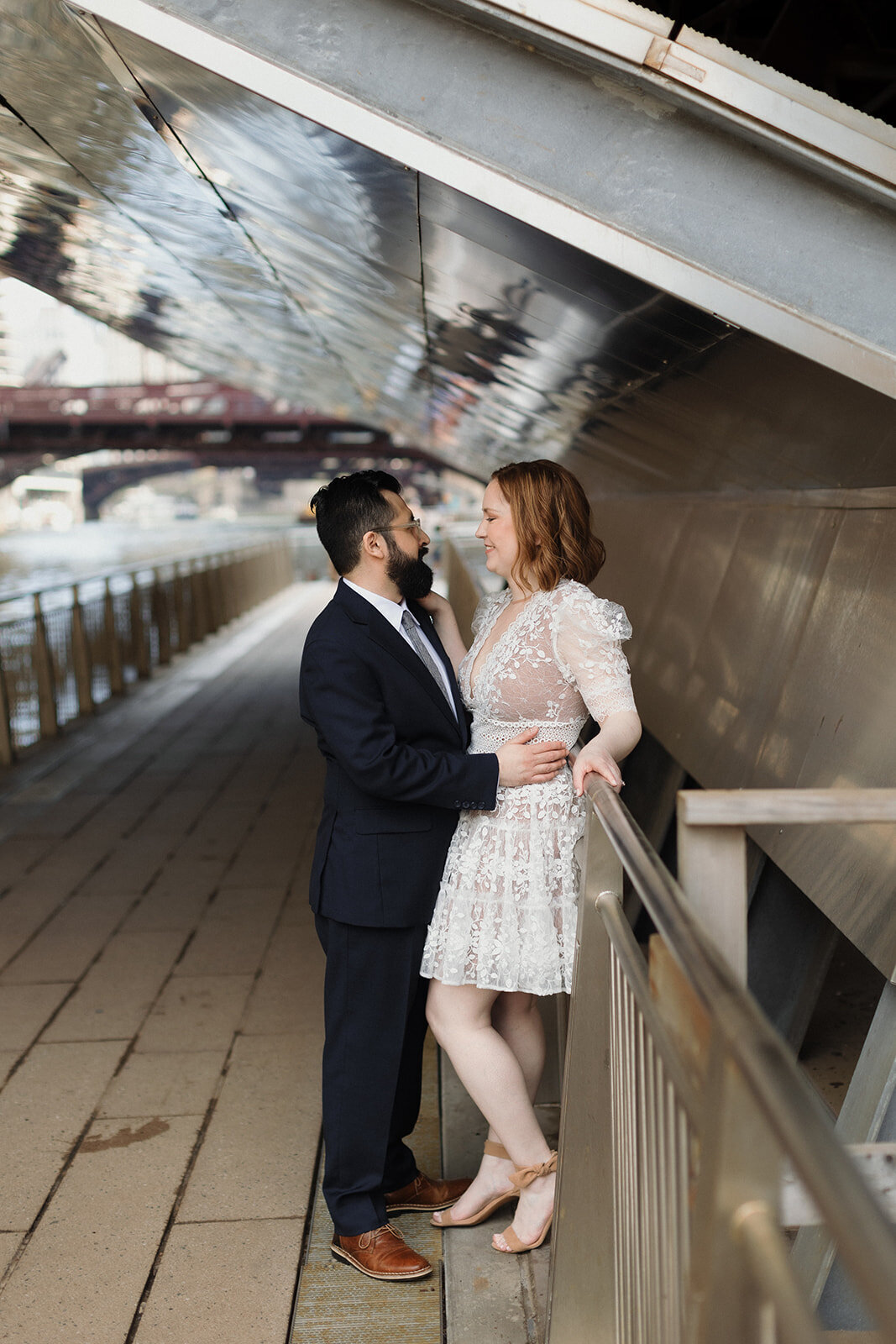 Elopement couple standing under Chicago River bridge very close to each other.