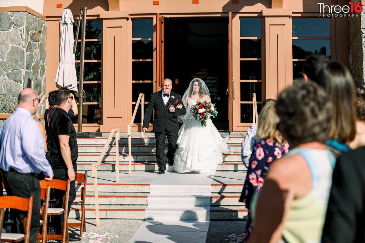 Bride and her father appear for the first time walking down the steps