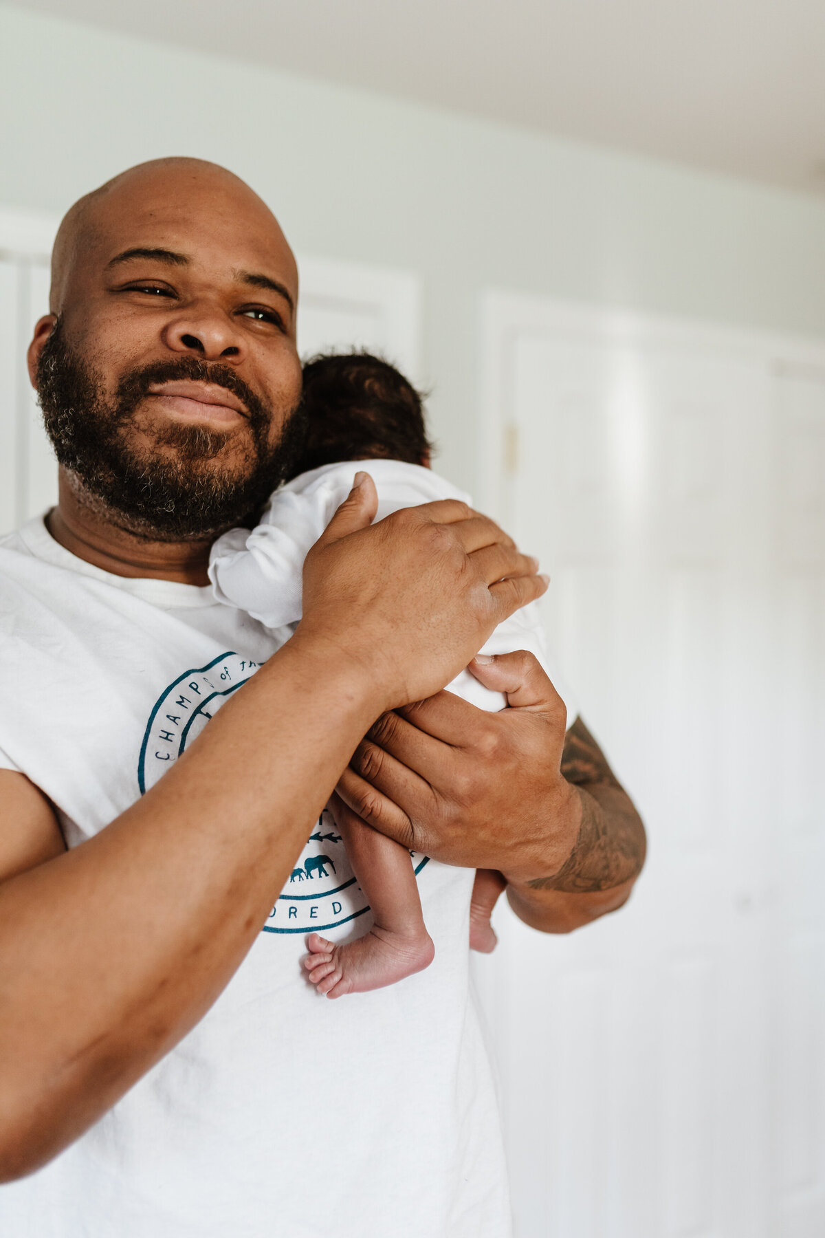 Newborn Photographer, dad holds baby close