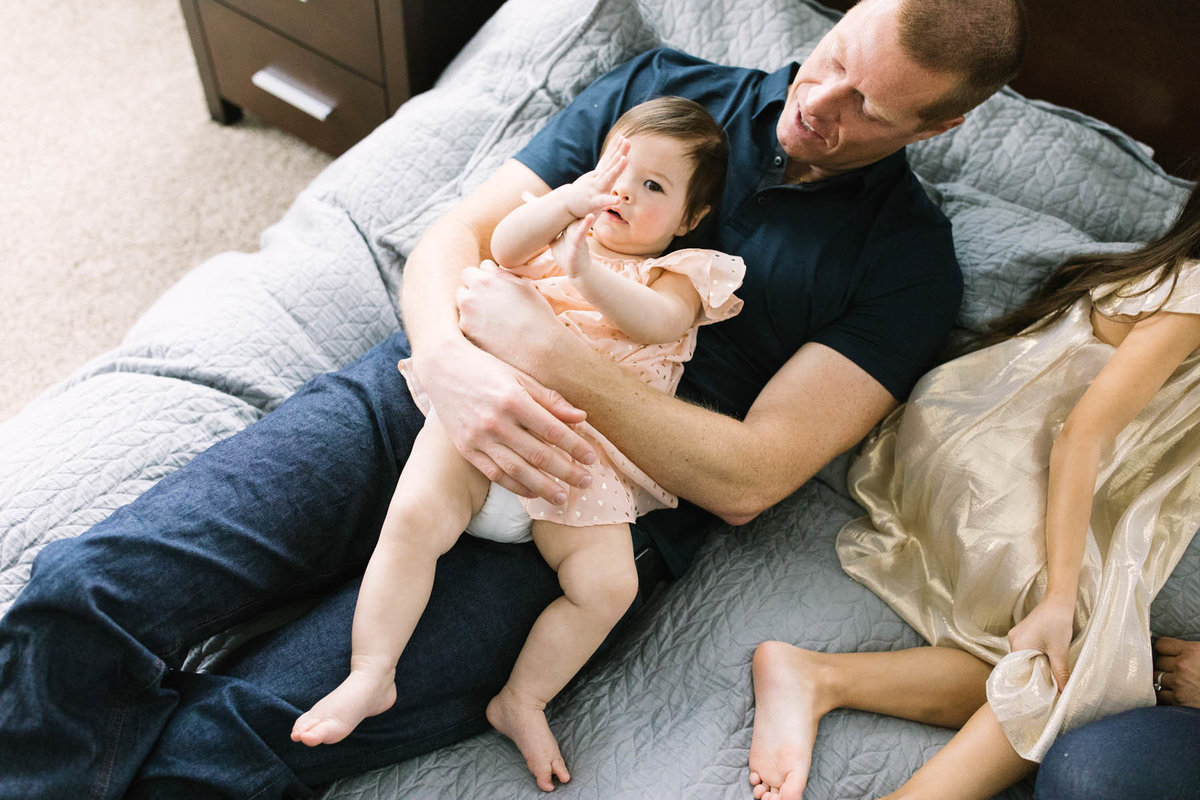 Dad laying with daughter during lifestyle session