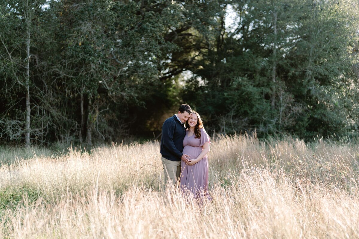 Pregnant couple embracing in a field
