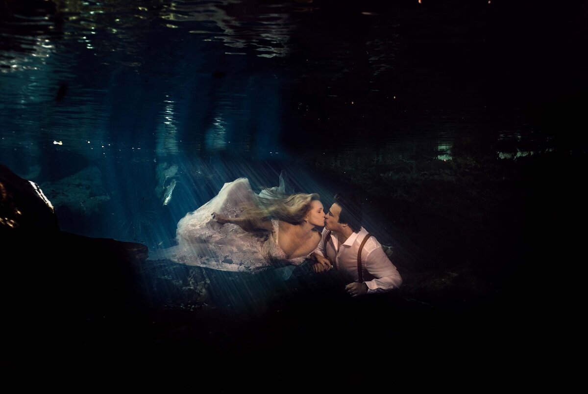 Bride and groom kissing underwater in trash the dress in Riviera Maya
