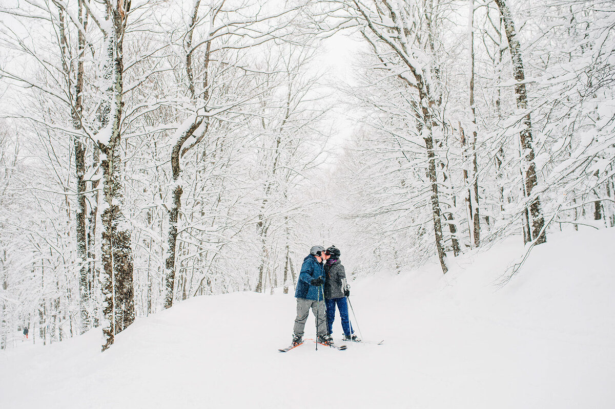 couple kissing on skis at stowe mountain lodge spruce peak winter wedding