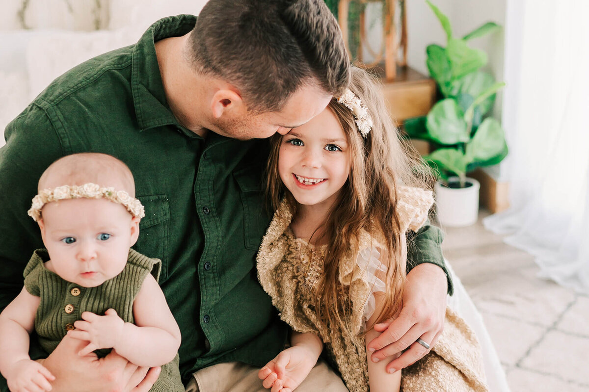 Springfield Mo family photographer The XO Photography captures dad kissing daughters forehead