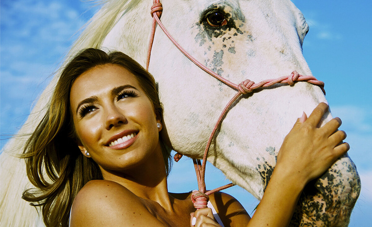 Country musician portrait Genevieve Fisher close up holding white horse reins