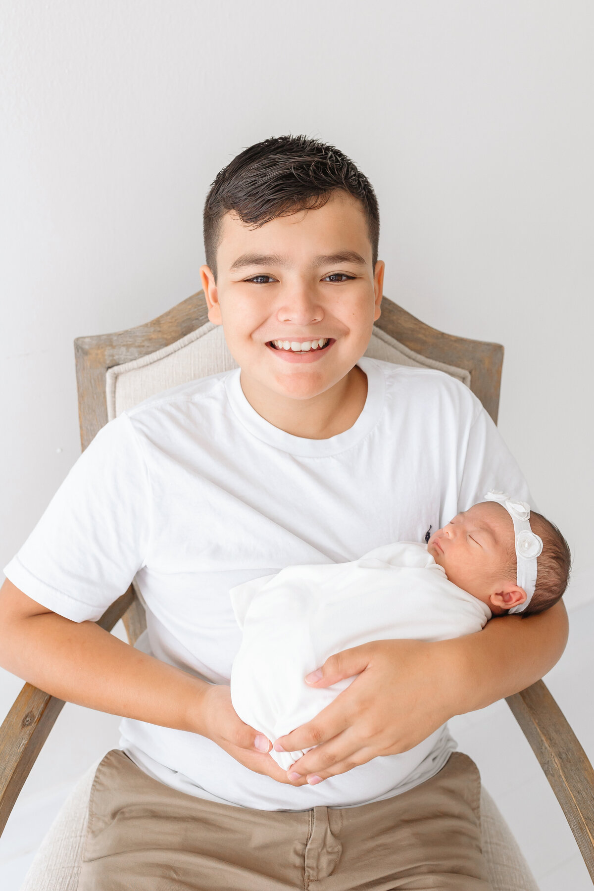 older brother holding newborn sister