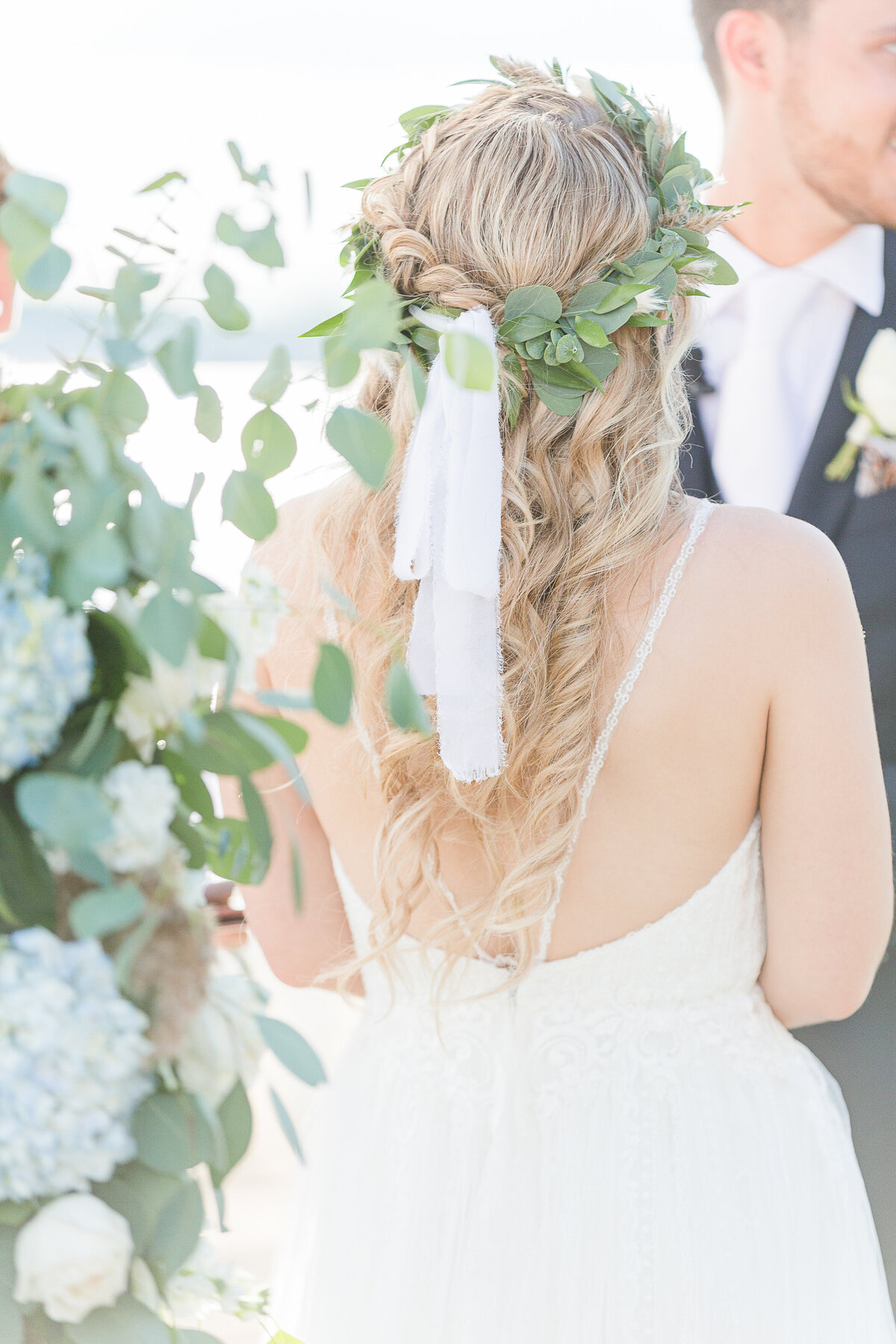 Detail image. The bride's back, hair and floral crown.
