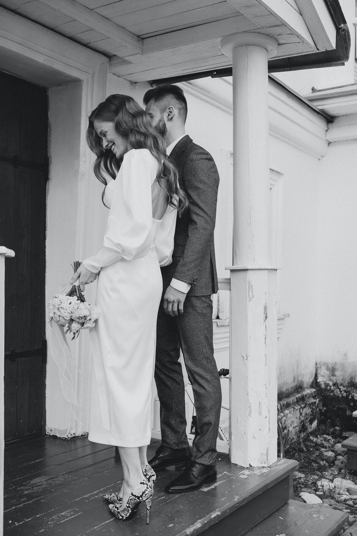 newlyweds-standing-by-wooden-door
