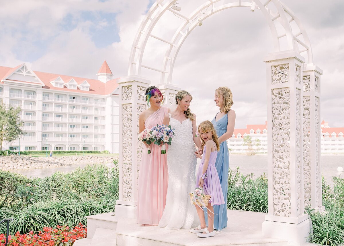 Bride poses with daughter under arch at Disney Wedding Pavilion