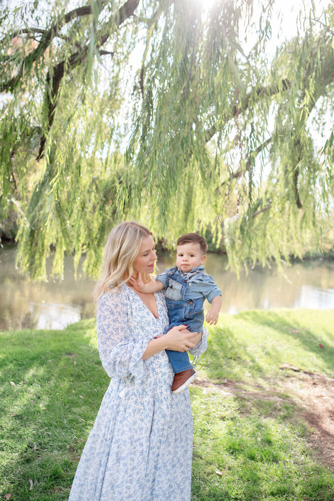 Family session of little boy and his mother outside near lake