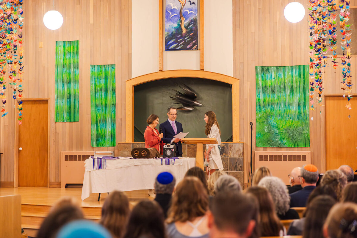 Mom and dad read their speech to their daughter on the bimah