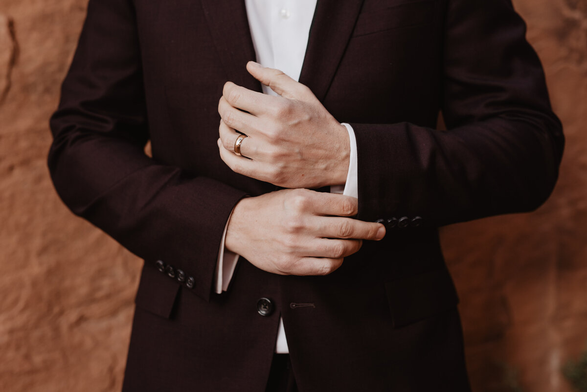 Utah elopement photographer captures groom adjusting buttons on sleeves