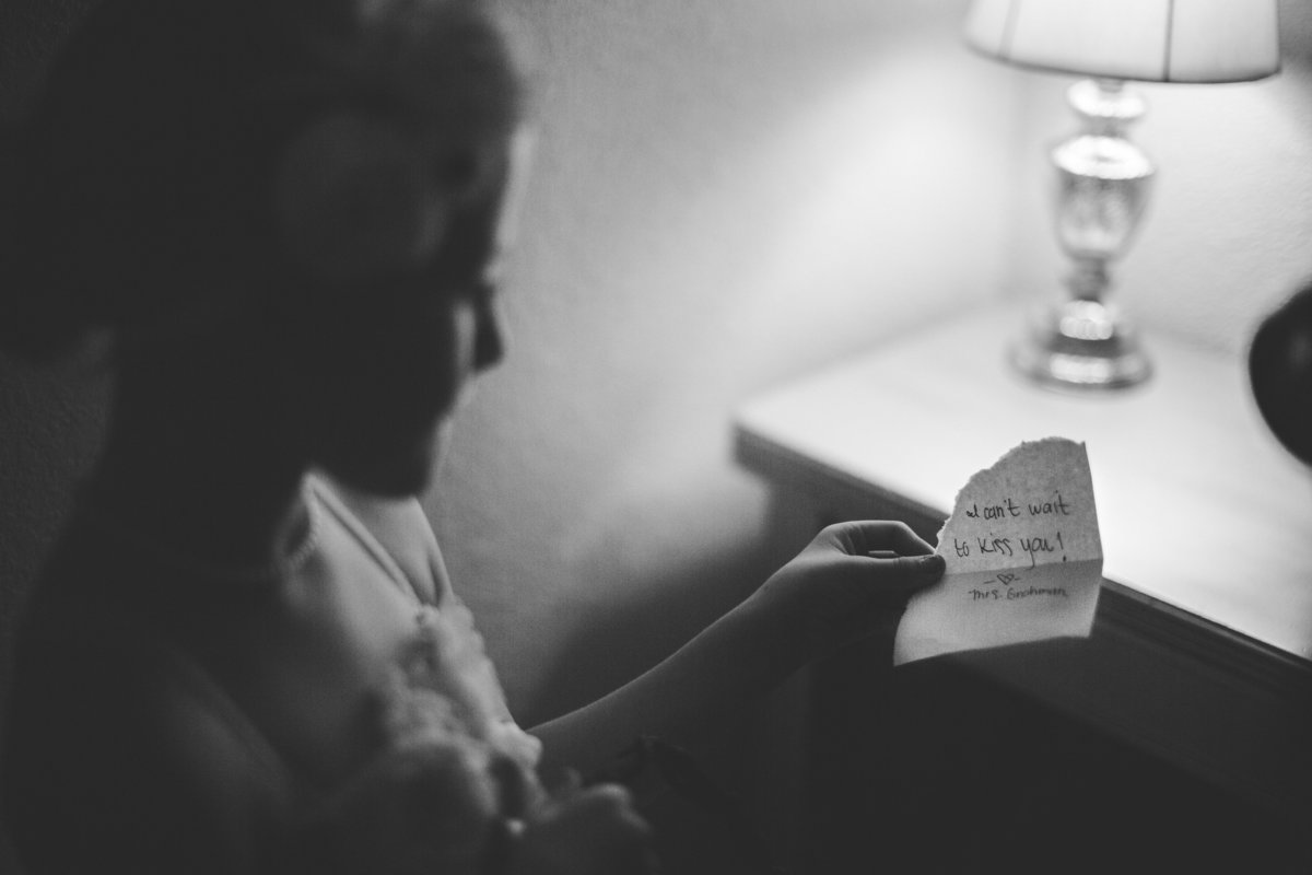 Bride at Vista West Ranch writes a quick note to give to groom while getting ready for wedding ceremony.