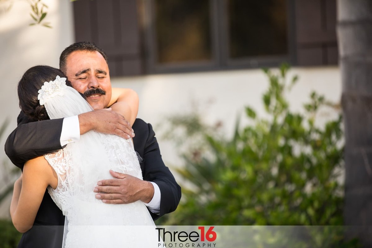 Father of the Bride hugs his daughter before her wedding ceremony