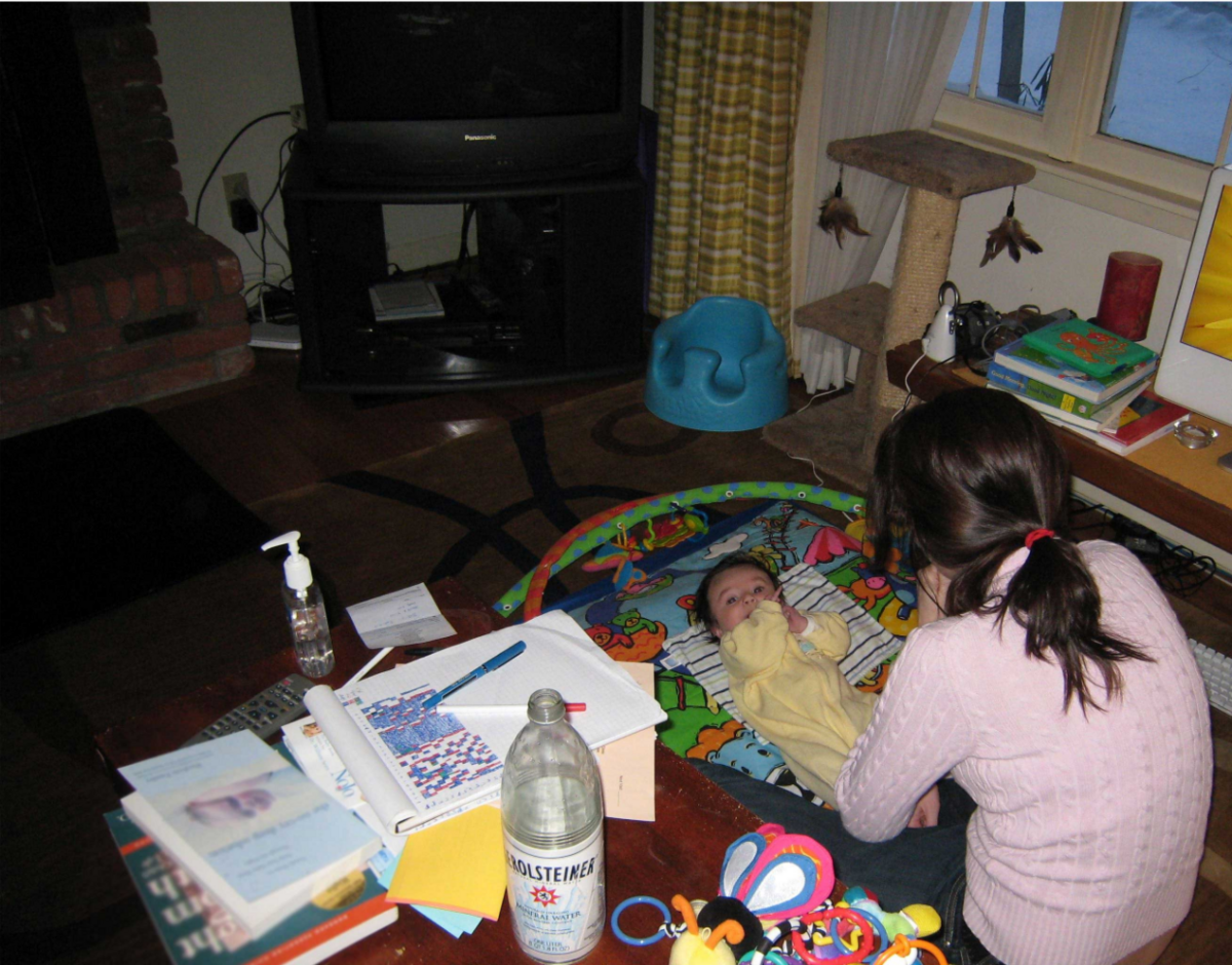 woman sitting on the floor looking at baby