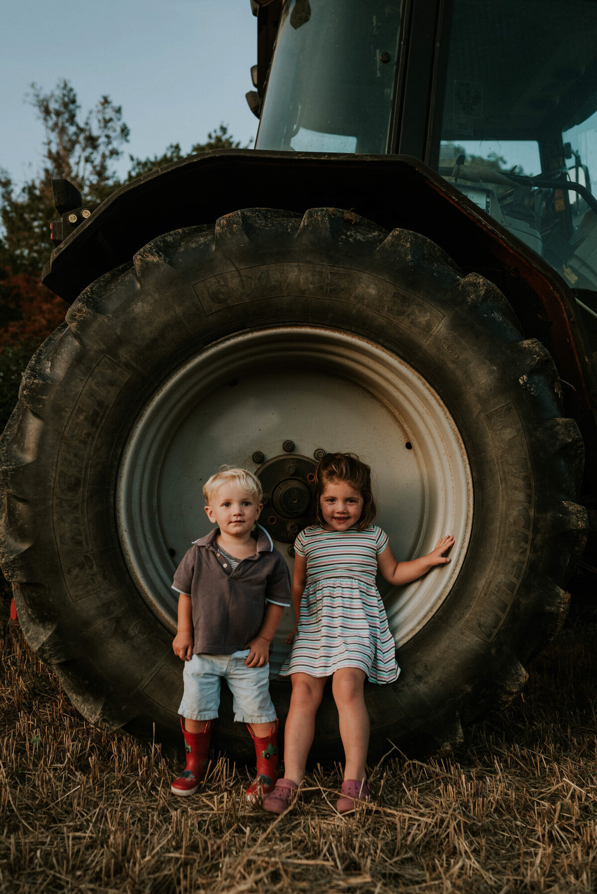 Small children in front of tractor tire