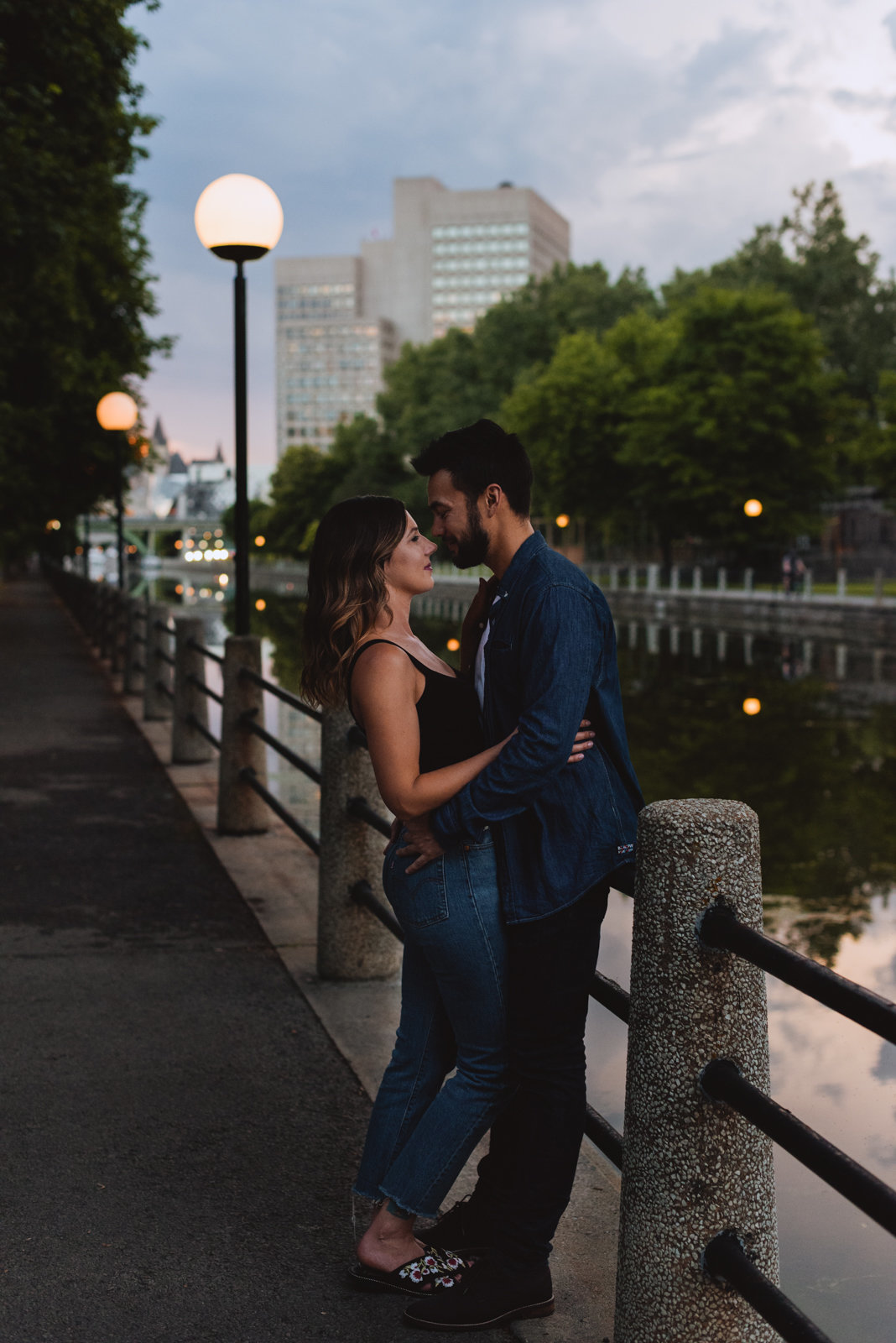 engaged couple by the canal at sunset