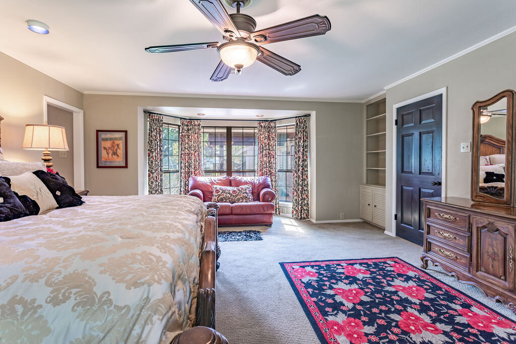 Spacious master bedroom with comfortable bedding and sofa in this 5-bedroom, 4-bathroom vacation rental house for 16+ guests with pool, free wifi, guesthouse and game room just 20 minutes away from downtown Waco, TX.