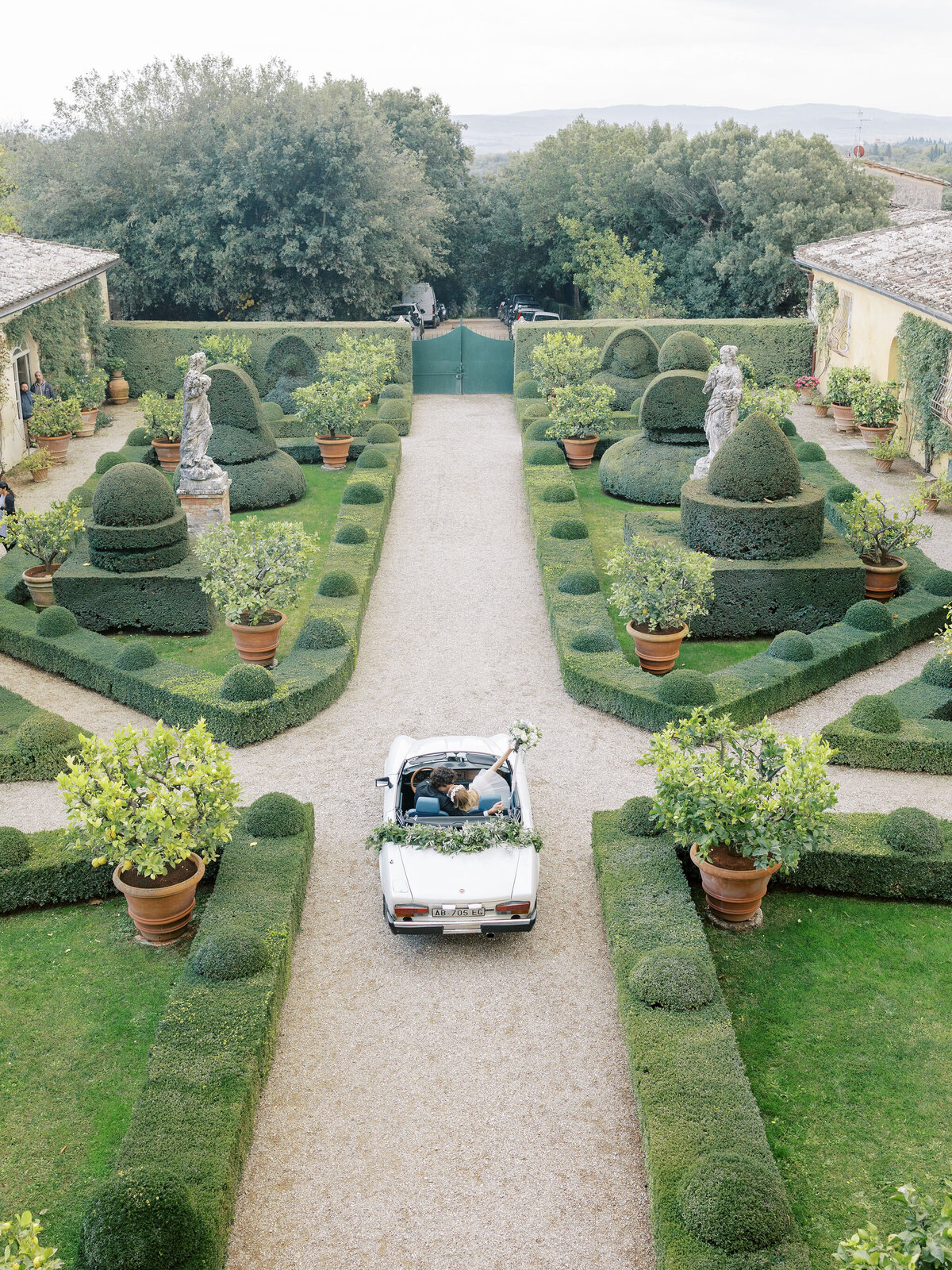 bride and groom kiss and drive away together after wedding at Villa Cetinale in Tuscany, Italy