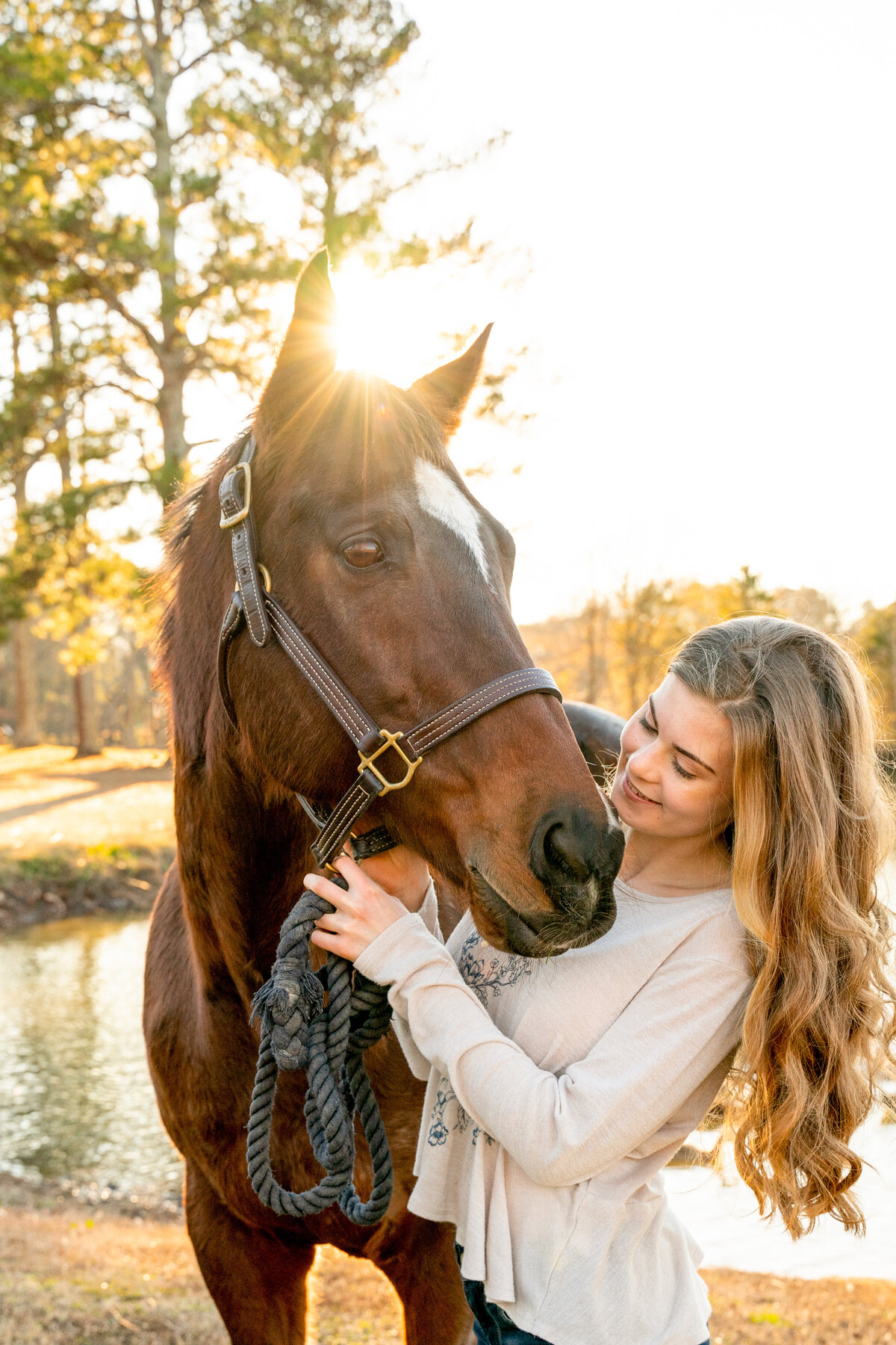 Lookout Mountain Senior Photographer Kelley Hoagland  takes portrait of teenager posed with horse during on-site photo shoot.