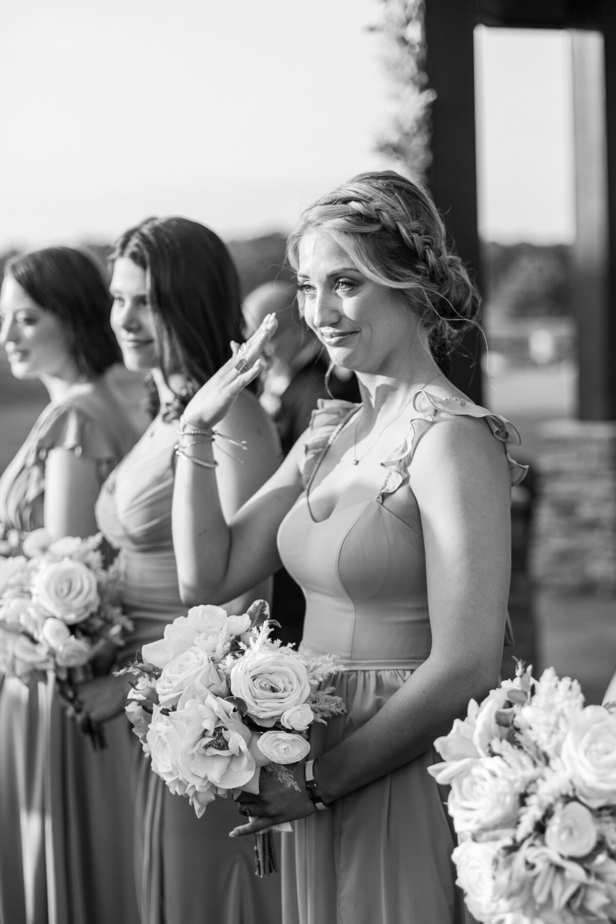 A bridesmaid reaches up to wipe away her tear when she sees her best friend walk down the aisle at her Charlotte area wedding.