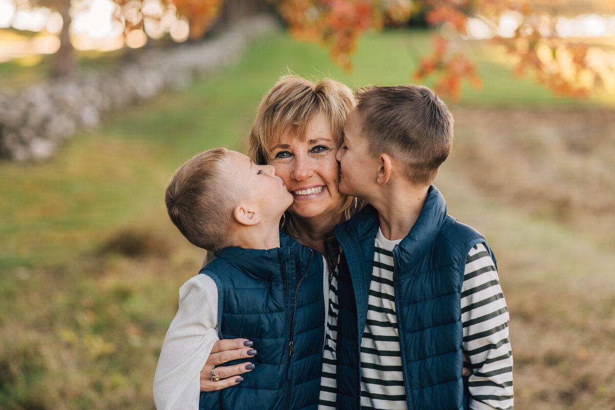 Two boys kissing their grandmother at their fall CT family session