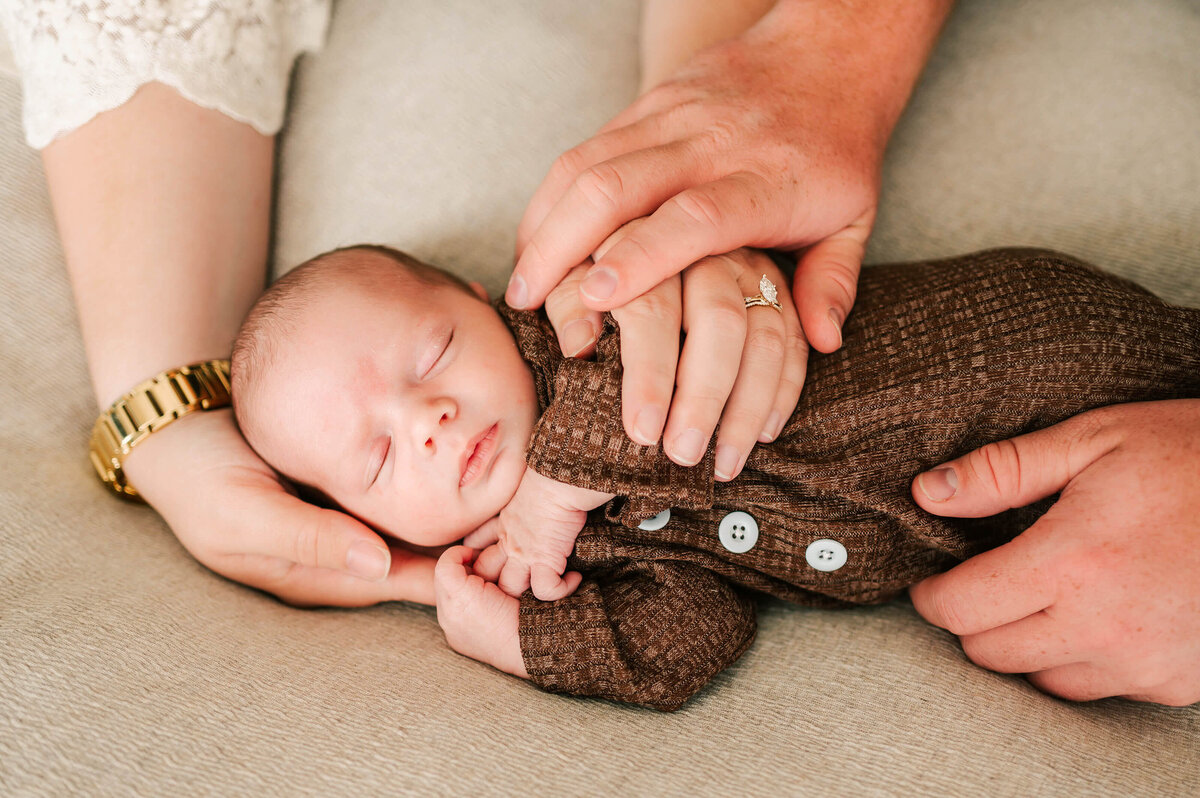 baby boy sleeping in parents hands captured by Springfield MO newborn photographer Jessica Kennedy of The XO Photography