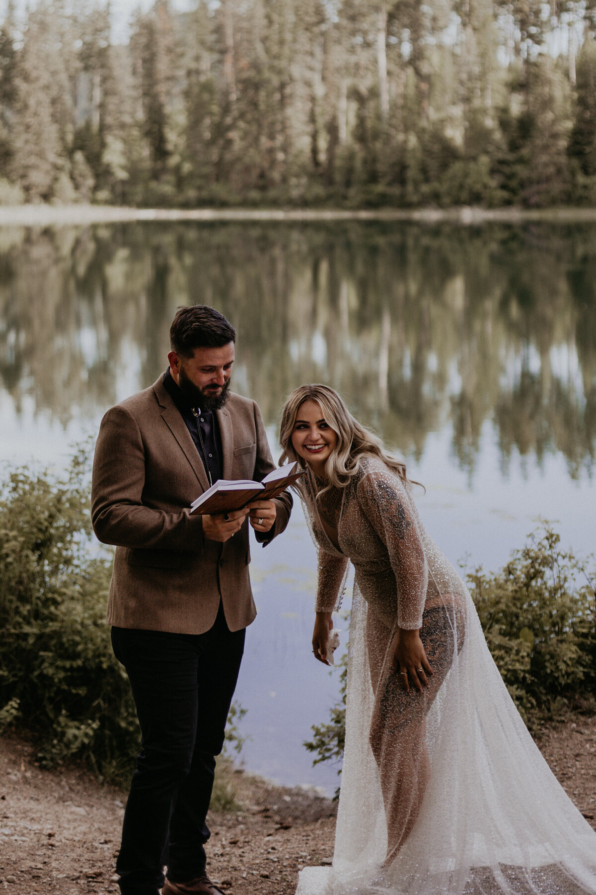 bride and groom laughing together while reading vows