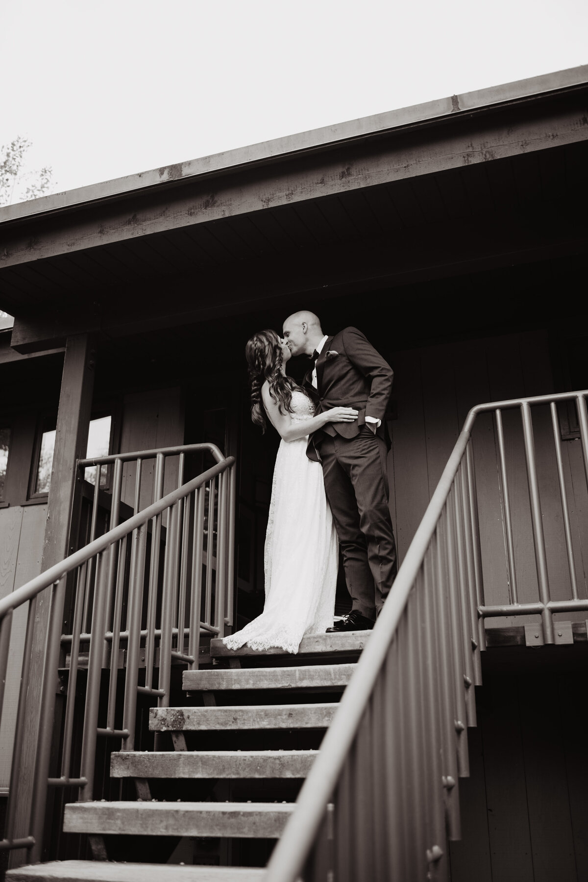 Jackson Hole photographers capture bride and groom kissing before walking down stairs