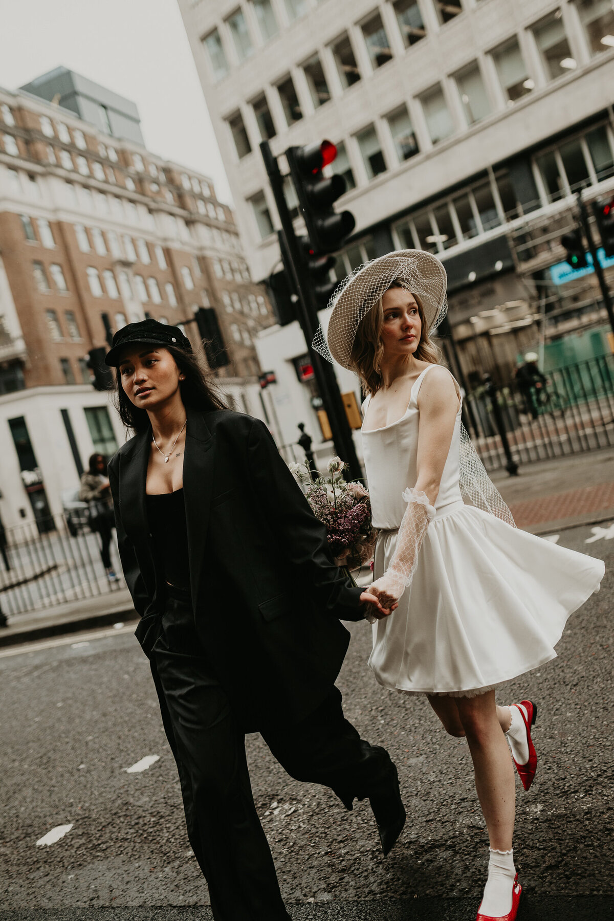 Same sex couple cross the road on their wedding day in London.