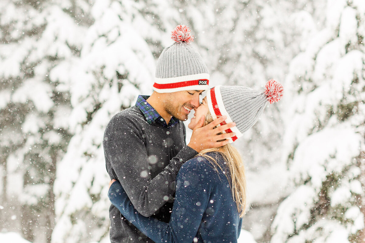 Fun and joyful engagement session in snow at Snoqualmie Pass near Seattle happy couple laughing wearing matching beanies candid photo by Joanna Monger Photography