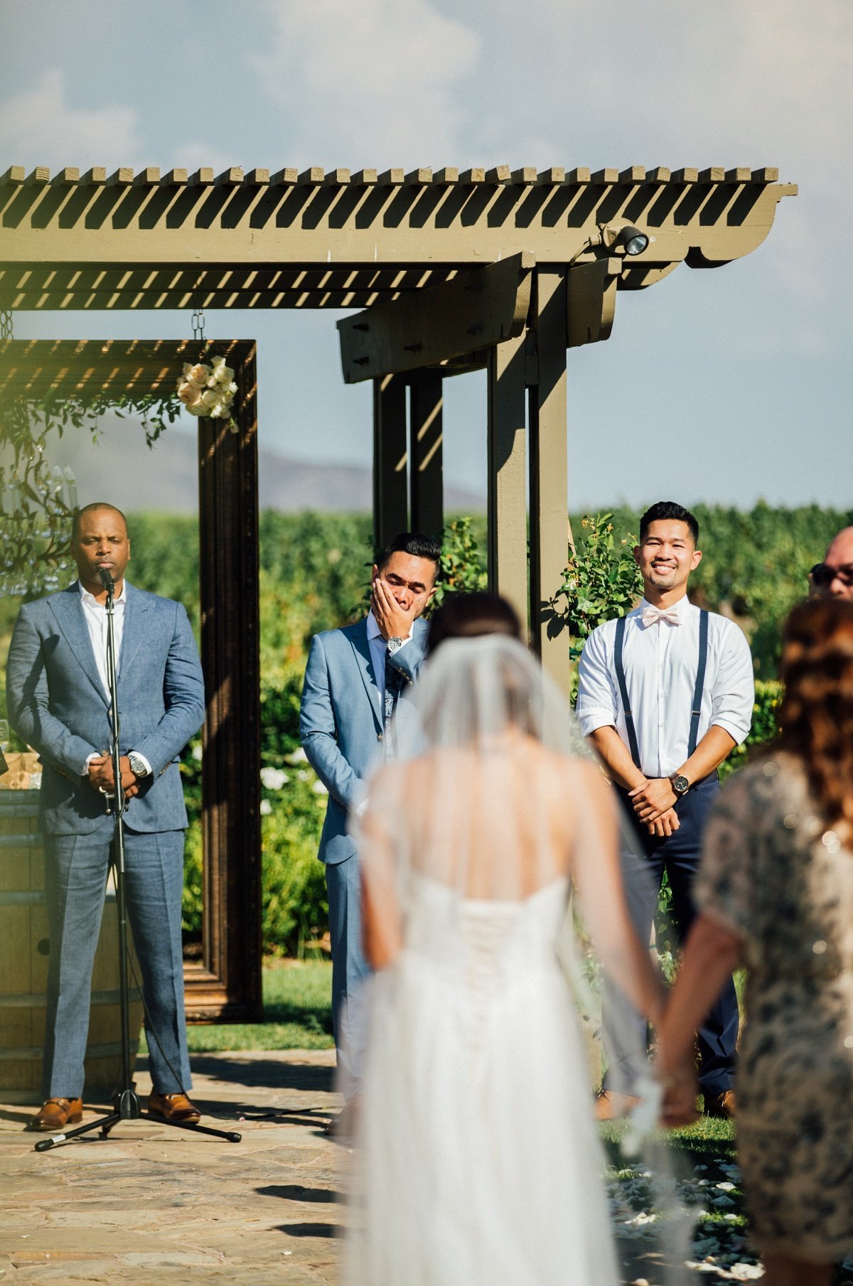 Groom stands at the altar holding back his emotions as the Bride walks up the aisle