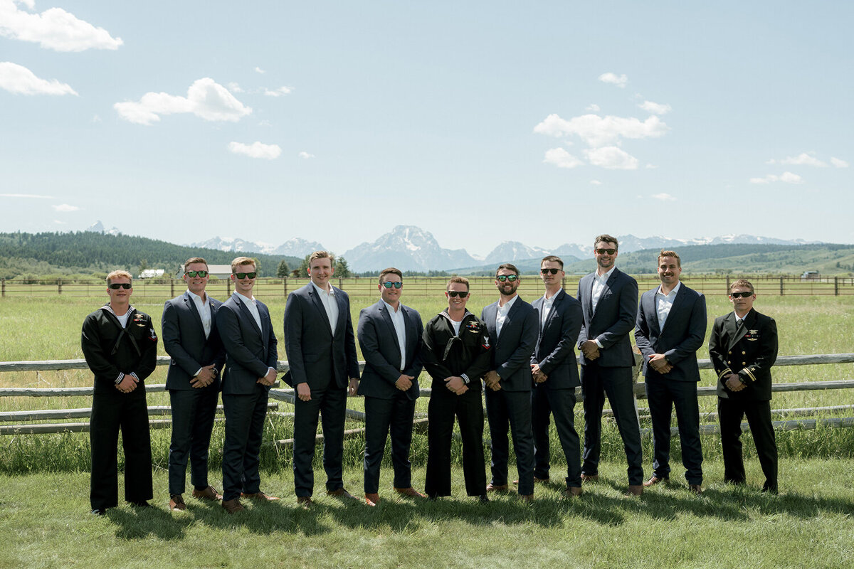 Groomsmen stand in front of the Teton Mountains during a French blue summer wedding in Jackson, Wyoming.