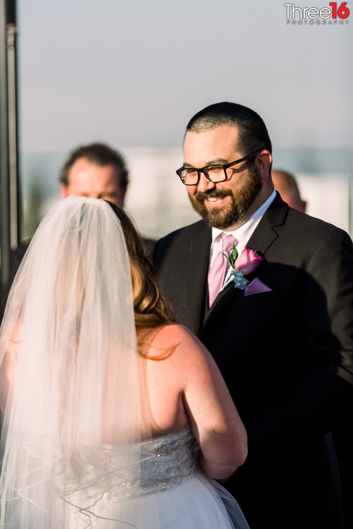 Groom gives his Bride a big smile as she reads her vows to him during the ceremony