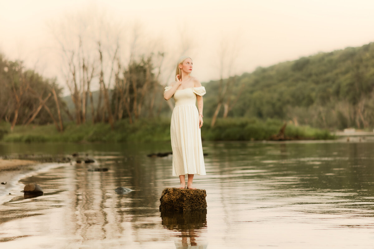 female standing in the river in Stillwater, MN wearing a white dress