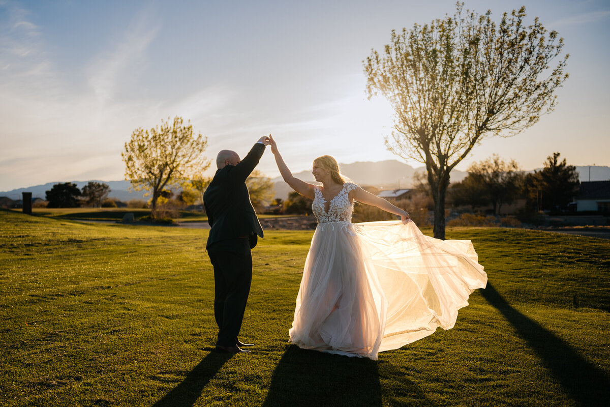 Newlyweds in love, dancing joyfully during a stunning sunset at Revere Golf Club in Las Vegas.