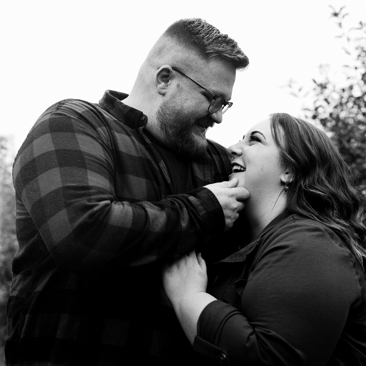 Couple snuggles at Lynd's fruit farm during engagement session