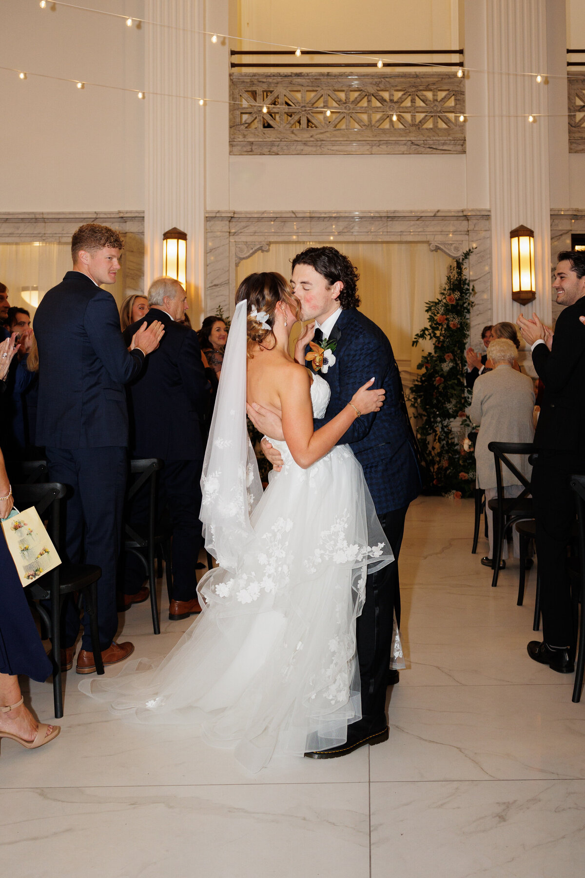bride and groom mid-aisle kiss