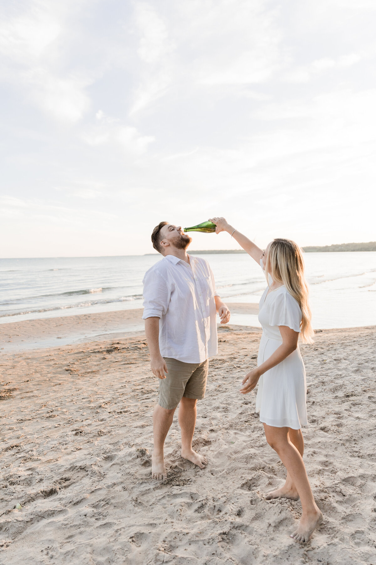 Couple pouring champaign on a beach